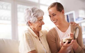 senior woman and her adult daughter looking at a gifted pearl necklace