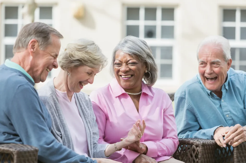 senior friends sitting outdoors on patio talking