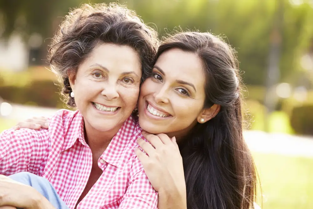 a woman with her arms around her senior mother with dementia